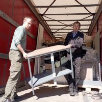 Чоловіки розвантажують гуманітарну допомогу
